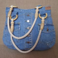 a purse made out of jeans with wooden handles and ropes attached to the front pocket