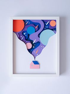 a paper cut art piece in a white frame on a wall with space and planets