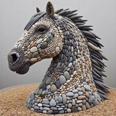 a horse made out of rocks sitting on top of a pile of sand and gravel