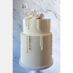 a three tiered cake with white flowers on top