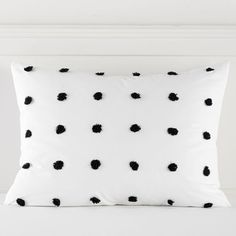 a white pillow with black polka dots on it