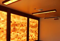 an empty room with some lights on the ceiling and large glass panels in the wall