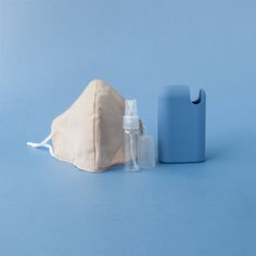 a face mask and mouthwash are sitting on a blue surface