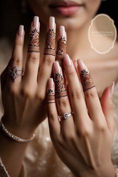 a woman holding her hands with henna tattoos on it