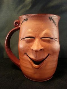 a ceramic mug with a smiling face on it