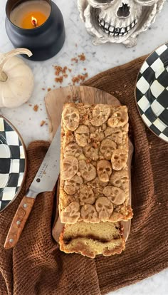 a loaf of bread sitting on top of a wooden cutting board next to a knife