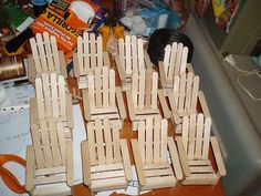 several wooden chairs sitting on top of a table next to a spool of thread