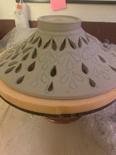 a white vase sitting on top of a wooden table