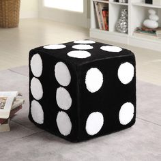 a black and white dice sitting on top of a rug next to a book shelf