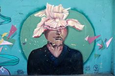 a painting of a man with a flower on his head in front of a blue wall