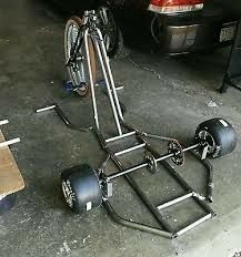 a bicycle is parked in the garage next to a cart that has wheels on it