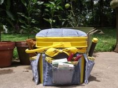 a blue and yellow suitcase with tools in it sitting on the ground next to potted plants