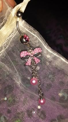 a close up of a bag with a cross on it and pearls hanging from the handle