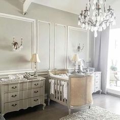 a baby's room with two cribs and a chandelier