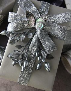 a gift wrapped in silver paper with a bow