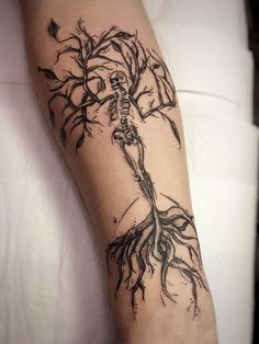 a person with a tattoo on their arm that has a tree growing out of it