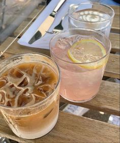 two drinks are sitting on a wooden table