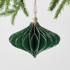 a green ornament hanging from a christmas tree