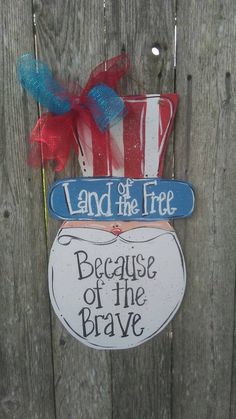 a wooden fence with a sign that says land of the free because of the brave