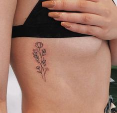 a woman's stomach with a flower tattoo on it