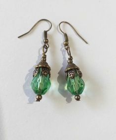 Emerald green Victorian bronze earrings Boho earrings Bronze earrings Bohemian earrings Vintage emerald green teardrop flower earrings gift boho earrings Edwardian earrings Gothic earrings Beautiful bronze Victorian style earrings with emerald green teardrop faceted glass beads. Antique style bronze tone Emerald green filigree earrings . Boho earrings. Bohemian earrings . Romantic style earrings. Baroque style earrings . Beautiful emerald-green earrings.  Perfect Gift for Her ! FREE SHIPPING  The Chain measures approximately 46 cm ( 18.20 inches). Material: bronze tone pendant, green teardrop faceted glass beads, bronze tone chain , bronze toned ornaments beads.  Length of necklace :  18.20 ( 46cm) Length of earrings with hooks - 1.7 (4.5 cm) If you have any question, please contact me ! T Green Crystal Metal Earrings, Green Metal Earrings For Gift, Green Dangle Crystal Earrings, Handmade Green Crystal Metal Earrings, Nickel Free Green Metal Earrings, Green Pierced Drop Earrings, Nickel-free Green Metal Earrings, Handmade Bohemian Green Crystal Earrings, Green Drop Earrings, Pierced