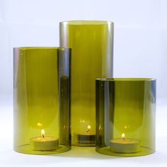 three green vases with lit candles in them