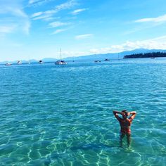 a man standing in the water with his hands behind his head