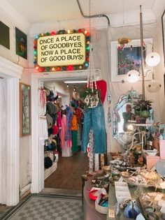 the inside of a clothing store with lots of items on display and lights hanging from the ceiling