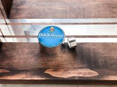 a wooden bench with a tin of duck mirror next to it