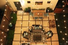 an overhead view of a living room and dining area with lights strung from the ceiling