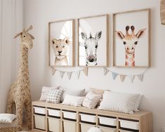 three framed giraffes hang on the wall above a bench with storage bins