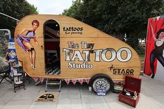 the tattoo studio trailer is parked on the side of the road