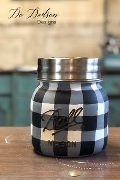 a black and white mason jar sitting on top of a wooden table