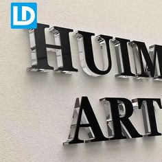 two metal letters that are on the side of a building, one says hum art