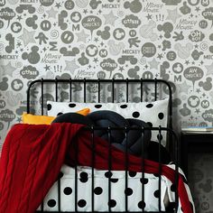 a black metal bed with mickey mouse wallpaper