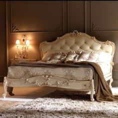 a white bed sitting in a bedroom on top of a carpeted floor next to two lamps