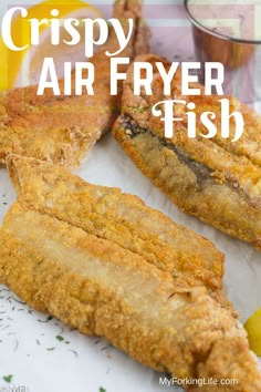 crispy air fryer fish on a plate with lemon wedges