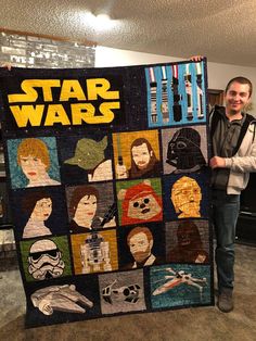 a man standing next to a star wars quilt