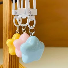 three plastic hearts hanging from hooks on a wooden rack