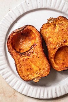 two pieces of bread sitting on top of a white paper plate with holes in it