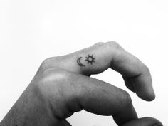 a hand with a small star and moon tattoo on it