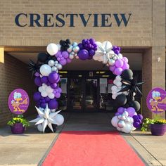 the entrance to crestview is decorated with purple and white balloons, starfish, and other decorations