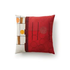 a red pillow sitting on top of a white wall