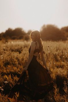 a woman in a dress standing in a field