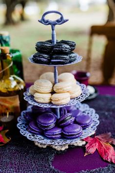 a table topped with three tiered trays filled with cookies and macaroons