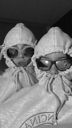 two people wearing sunglasses and hooded clothing