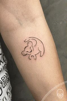 a small elephant tattoo on the left forearm and arm, with an outline of a baby elephant