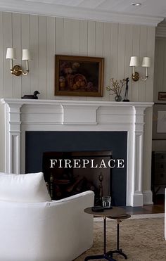 a living room with a fire place next to a white couch and coffee table in front of a fireplace