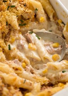 a casserole dish filled with pasta and meat in a creamy sauce, garnished with parmesan cheese