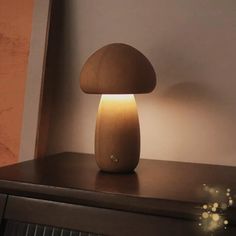 a mushroom shaped lamp sitting on top of a wooden table next to a dresser drawer